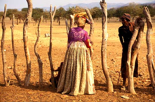 Herero woman talking to Himba shepheard