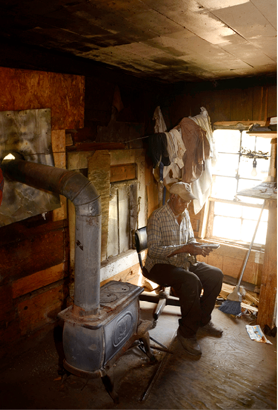 2012 - Old man with cell phone in his shack, Perry County, AL 